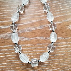 Clear and opaque plastic beaded necklace.